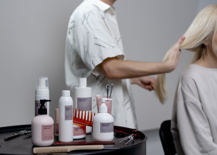 Stylistin arbeitet an den Haaren einer Kundin
